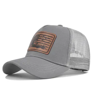 Detail view of grey trucker hat featuring breathable mesh back and brown leather hunting flag patch.