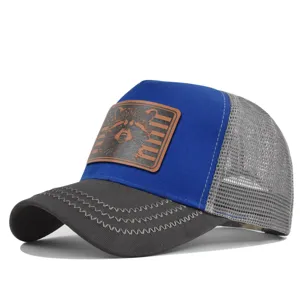 Detailed view of the mesh baseball cap with blue front panel and cute raccoon leather patch.