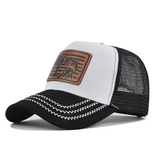Close-up detail of mesh trucker cap showcasing contrast leather patch and zigzag brim embroidery.