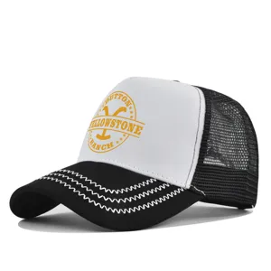 Gorra trucker de malla en blanco y negro con estampado Yellowstone ranch y costuras en zigzag.