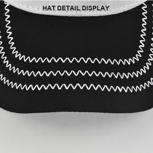 Primo piano della visiera del berretto nero con dettagliate cuciture a zig-zag bianche.