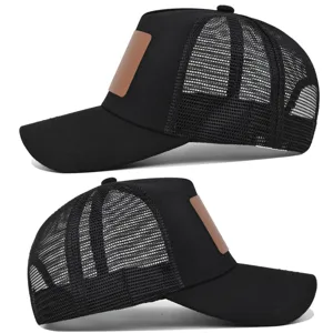 Klassieke zwarte trucker pet met ademende mesh achterkant en een bruine lederen patch voorop.