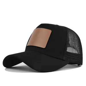 Details van de zwarte truckerpet met blanco bruine lederen patch en ademende mesh achterkant.