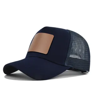 Donkerblauwe truckerpet met blanco bruin lederen patch en ademende mesh achterkant voor de zomer.