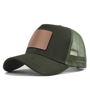 Groene trucker pet met blanco lederen patch, ademende mesh achterkant en gebogen klep.