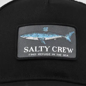 Schwarze Trucker Cap Detail mit besticktem Haifisch Aufnäher und Angler Logo Design.