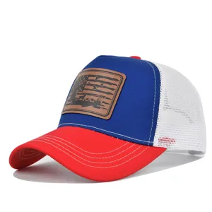 Detailed view of the red, blue and white trucker hat featuring a brown hunting leather patch.