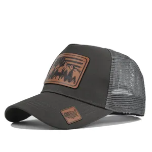 Detail view of dark grey trucker hat with mesh back and hunting deer leather patch.