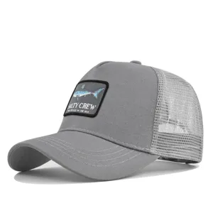 Graue Trucker Cap mit gesticktem Hai-Patch, gebogenem Schirm und atmungsaktivem Mesh-Netzteil.