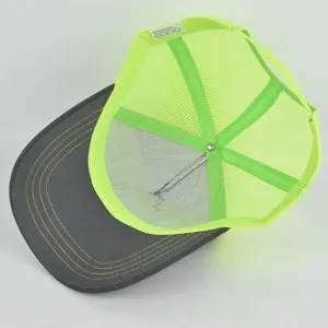 Detailansicht einer Sommer Mesh Baseballkappe mit grauem Schirm und gruenem Einsatz.