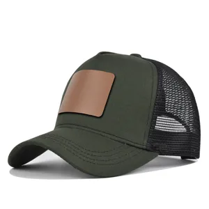 Donkergroene mesh trucker honkbalpet met een lege bruine lederen patch voor de zomer.