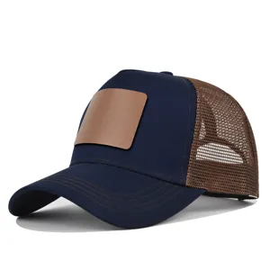 Donkerblauwe truckerpet met bruine mesh achterkant en blanco lederen patch voor logo.
