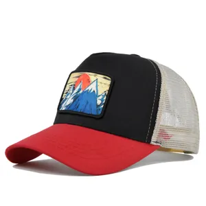 Nahaufnahme der stylischen Trucker Cap mit Berg-Aufnäher, rotem Schirm und Netzeinsatz.