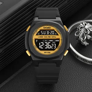 Black digital sports watch detail with gold dial display and silicone strap closeup.