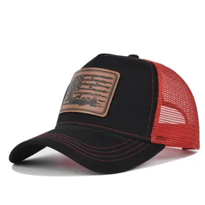 Close-up detail of the black and red trucker hat featuring a rustic leather patch.