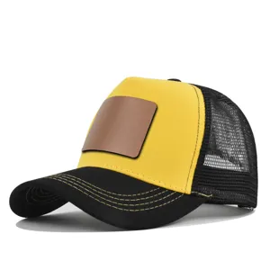 Gedetailleerd uitzicht van de gele en zwarte trucker pet met bruine lederen patch.