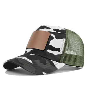 Gedetailleerd overzicht van camo trucker cap met lege lederen patch en mesh achterkant.