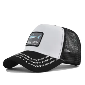 Schwarz-weiße Trucker Cap mit Mesh-Rücken, gebogenem Schirm und besticktem Haifisch-Patch.