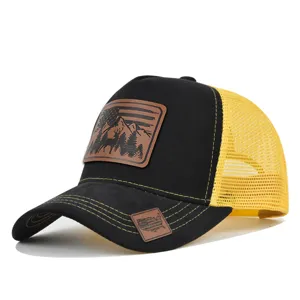 Detail view of the black and yellow mesh trucker hat with deer leather patch and curved brim.