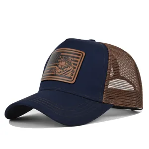 Detailansicht der dunkelblauen Trucker Cap mit braunem Mesh und Tiger Lederaufnäher.