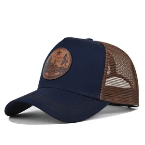 Gorra de camionero azul marino clásica con malla marrón y parche de cuero vintage.