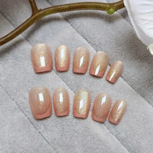 Detalle de uñas postizas hechas a mano con un elegante diseño francés de ojo de gato.