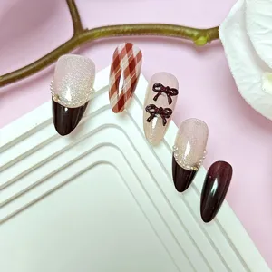 Uñas postizas hechas a mano con efecto ojo de gato, cuadros, perlas y lazos bonitos.