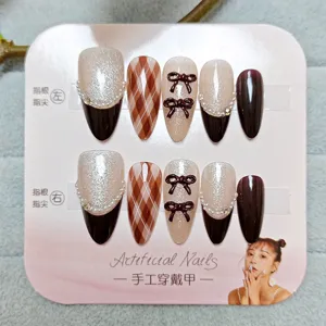 Set de uñas postizas hechas a mano con patrón de cuadros, ojo de gato, perlas y lazos.