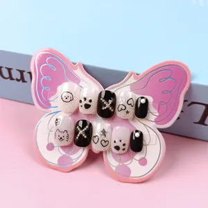 Detalle en primer plano de uñas postizas de dibujos animados en tarjeta de mariposa.