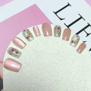 Uñas postizas cortas hechas a mano con efecto ojo de gato, flores secas y estrás.