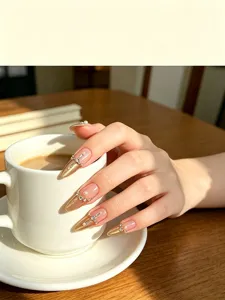 Uñas postizas artesanales con diseño French cat-eye dorado, perlas y pedrería brillante.