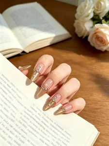 Uñas postizas stiletto hechas a mano con ojo de gato dorado, perlas y cruz de cristal chic.