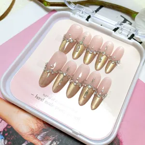 Uñas postizas hechas a mano de lujo, forma de almendra con ojo de gato francés dorado y perlas.