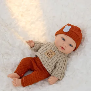 Detailed view of an 11-inch reborn baby doll toy set wearing a knit sweater and orange pants.