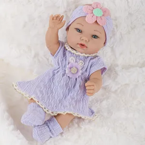 Detailed shot of 11-inch reborn baby doll featuring purple knit dress, cute headband and socks.