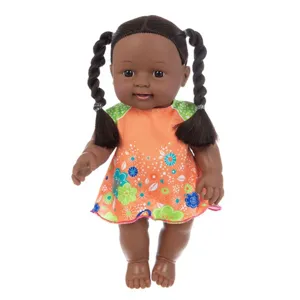 Primer plano de un tierno muñeco bebé africano de 12 pulgadas con coletas y vestido floral bonito.