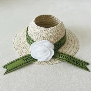 Woven doll straw hat with green ribbon and white camellia flower accessory for cute dolls.
