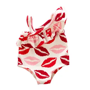 Detailed view of the cute doll swimsuit featuring a stylish red lip print and ruffle trim.