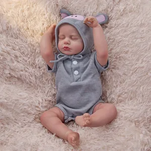 Close-up of the cute reborn doll wearing gray hooded romper on soft fluffy blanket background.