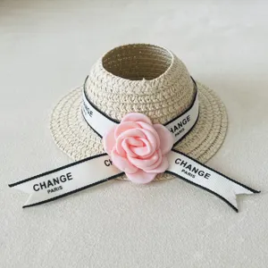 Miniature woven straw hat doll accessory with pink flower and ribbon for plush toys.