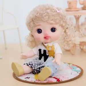 Detail view of a 9-inch vinyl dress-up doll with curly blonde hair and cute outfit.