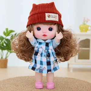 Detailed shot of a cute 9-inch vinyl doll wearing a chic brown knit hat and blue plaid dress.