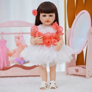 Detailed view of the 18-22 inch reborn baby doll wearing a cute pink dress with floral accessories.