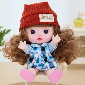 Detailed close-up shot of a cute 9-inch vinyl doll wearing an orange knit hat and blue dress.