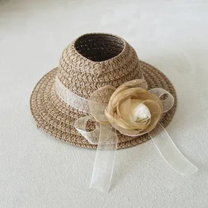 Detailed closeup view of stylish woven doll straw hat featuring a delicate sheer flower ribbon.