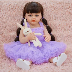 Detail shot of cute reborn doll wearing purple dress and holding plush rabbit toy on pink rug.