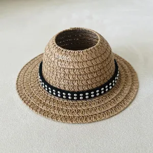 Detailed view of the woven straw doll hat with black studded band, perfect doll accessory.