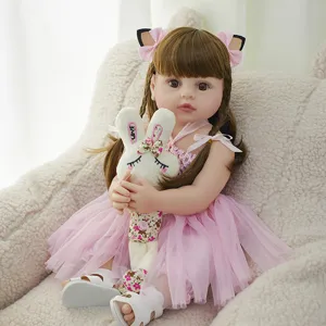 Reborn baby doll detail view showcasing soft brown hair, pink dress, and cute toy item.
