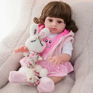 Detailed view of cute reborn baby doll with plush rabbit toy and pink outfit in cozy setup