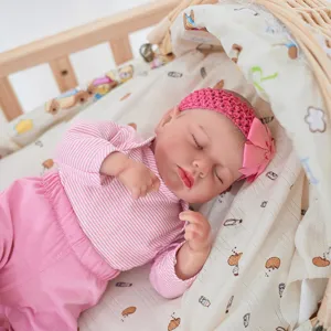 Gros plan détaillé d'un poupon reborn réaliste dormant paisiblement en tenue rose.